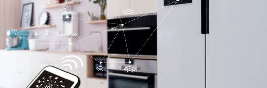 View of smart home from kitchen with appliances being operated by a mobile device.